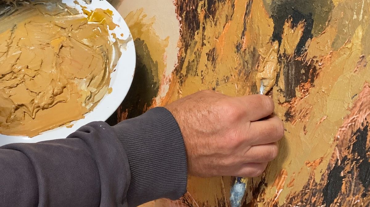 Martin Osner working paint into a picture with a palette knife